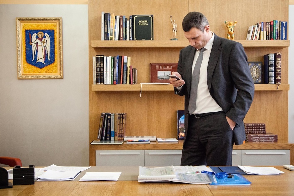 Vitaly Klichko, excampeón del mundo de boxeo y alcalde de Kiev, revisa su móvil en su despacho. (Juan TEIXEIRA)