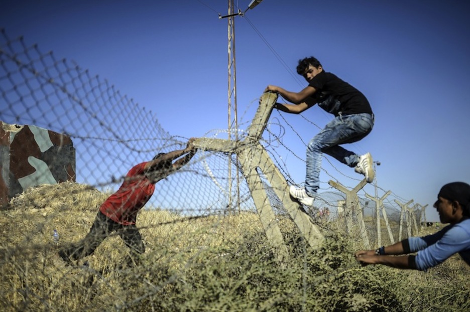 Kurdu talde bat Turkia eta Siriako estatuen arteko harresia bota nahian. (Bulent KILIC) Kurdu talde bat Turkia eta Siriako estatuen arteko harresia bota nahian. (Bulent KILIC)