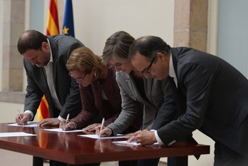 Junqueras (ERC), Nuria de Gispert (presidenta del Parlament), Dolors Camats (ICV) y Josep Turull (CiU) firman el documento. (Josep LAGO/AFP)