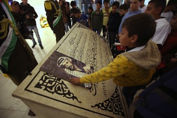 Un niño palestino coloca una foto de Arafat en su mausoleo de la Mukata. (Abbas MOMANI/AFP)