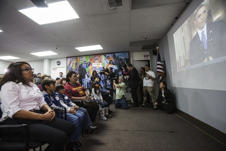 Miemros de la Coalición pro Derechos Humanos de la Inmigración en Los Angeles, siguen la intervención de Barack Obama en una pantalla gigante. (Ringo CHIU / AFP)