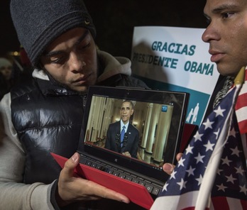 Miemros de la Coalición pro Derechos Humanos de la Inmigración en Los Angeles, siguen la intervención de Barack Obama en una pantalla gigante. (Ringo CHIU / AFP)