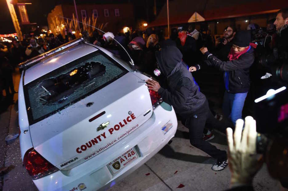 Manifestantes vuelcan un coche de la Policía en Ferguson (JEWEL SAMAD / AFP). 
