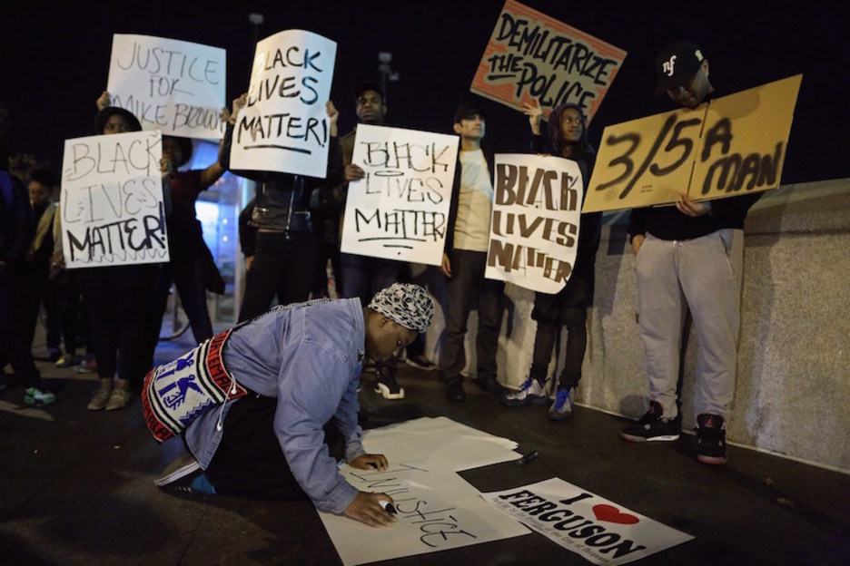 Una joven escribe «injusticia» entre varios protestantes en Washington. (Chip SOMODEVILLA / AFP)