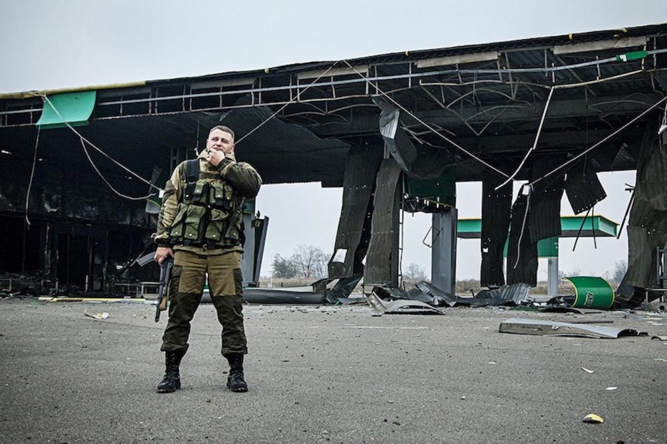 ‘Krest’, uno de los comandantes del batallón ‘Vostok’, ante una gasolinera destruída durante los conflictos con las tropas ucranianas. (Juan TEIXEIRA)