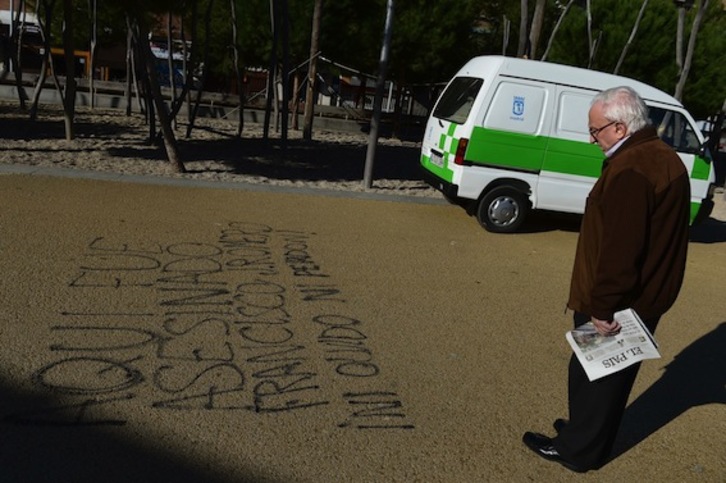 Un hombre observa una pintada en el suelo en la que pone «Aquí fue asesinado Francisco Romero». (Pierre-Philipppe MARCOU/AFP) 