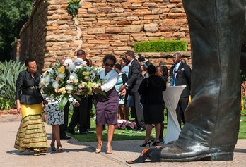 Graça Machel, viuda de Mandela, deposita un ramo de flores en la estatua en honor al expresidente sudafricano en Pretoria. (Stefan HEUNIS/AFP) 