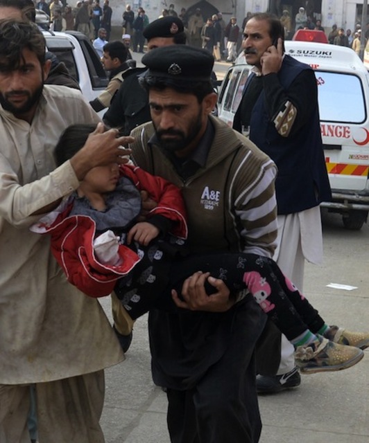 Dos hombres trasladan a un niño herido en el ataque. (A MAJEED/AFP PHOTO)