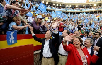 Camps, a la izquierda, saluda junto a Rajoy y Barberá a los asistentes a un mitin del PP. (José JORDAN / AFP)