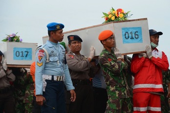 Oficiales indonesios trasladan un ataúdo con restos de los pasajeros fallecidos del avión de AirAsia. (Adek BERRY/AFP)