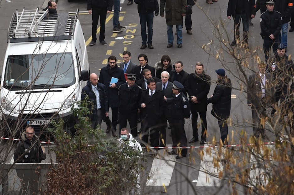 El primer ministro, Manuel Valls, con el prefecto de París, Bernard Boucault, en el exterior de la sede del semanario. (Martin BUREAU/AFP) 
