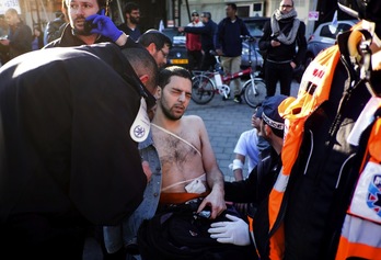 Uno de los heridos en Tel Aviv es atendido por los servicios médicos. (Yotam RONEN / AFP)