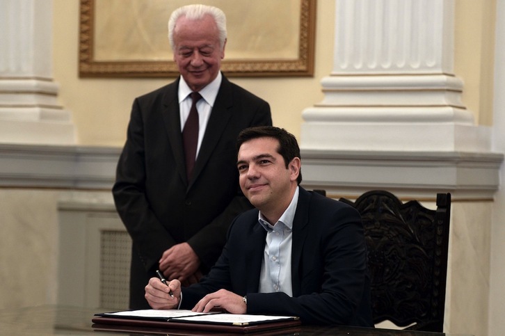 Alexis Tsipras firma el decreto de nombramiento durante la ceremonia de juramento como primer ministro. (Aris MESSINIS/AFP)