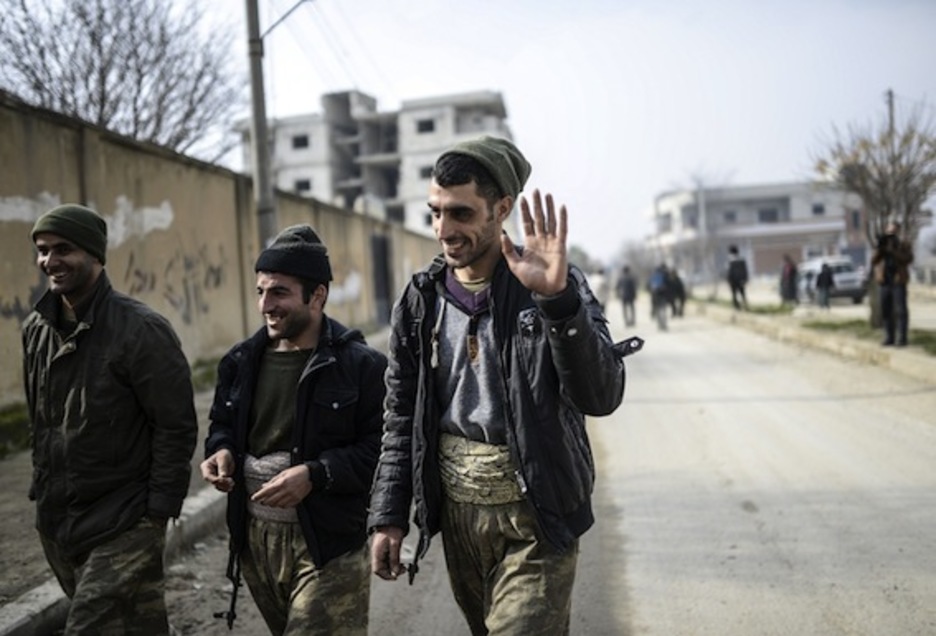 Tres milicianos, sonrientes tras su victoria sobre el EI en Kobane. (Bulent KILIC/AFP PHOTO)