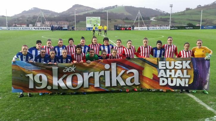 Bi taldeko jokalariak Korrikaren aldeko pankartarekin. 
