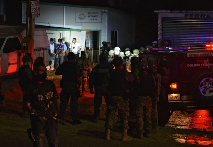 Forenses y miembros de las fuerzas de seguridad, en el crematorio. (AFP PHOTO)
