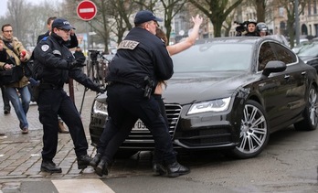 La Policía aparta a una activista de Femen que se había avalanzado sobre el coche en el que iba Strauss-Khan. (Denis CHARLET/AFP PHOTO)