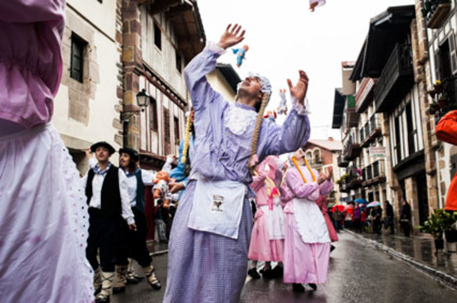 Ils font le passe-rue, tout en jetant en l'air la poupée qu'ils tiennent dans leurs bras. ©Eliane Héguiaphal