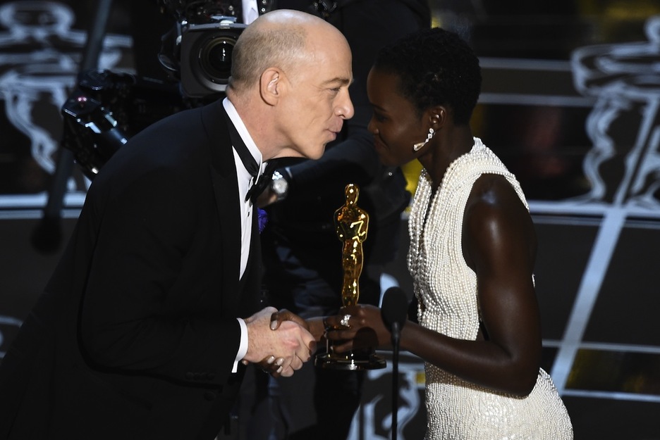 Lupita Nyong'o entrega a J.K. Simmons el premio al mejor actor secundario. (Robyn BECK / AFP)  
