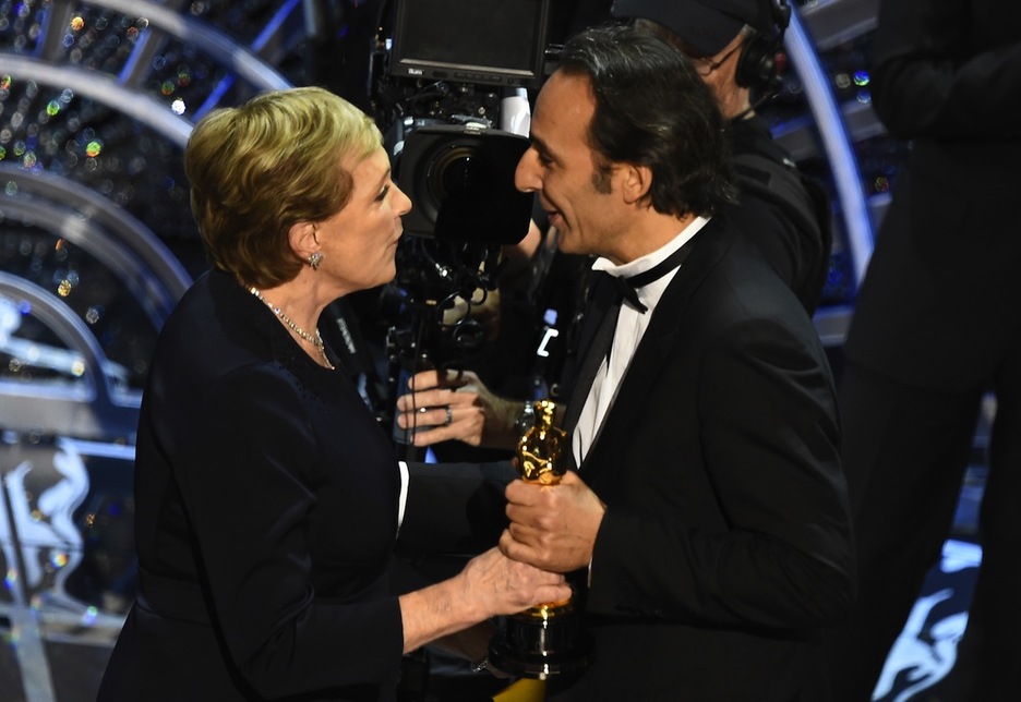 El compositor Alexandre Desplat recibe de Julie Andrews el premio a la mejor banda sonora por su trabajo en ‘El Gran Hotel Budapest’. (Robyn BECK / AFP)