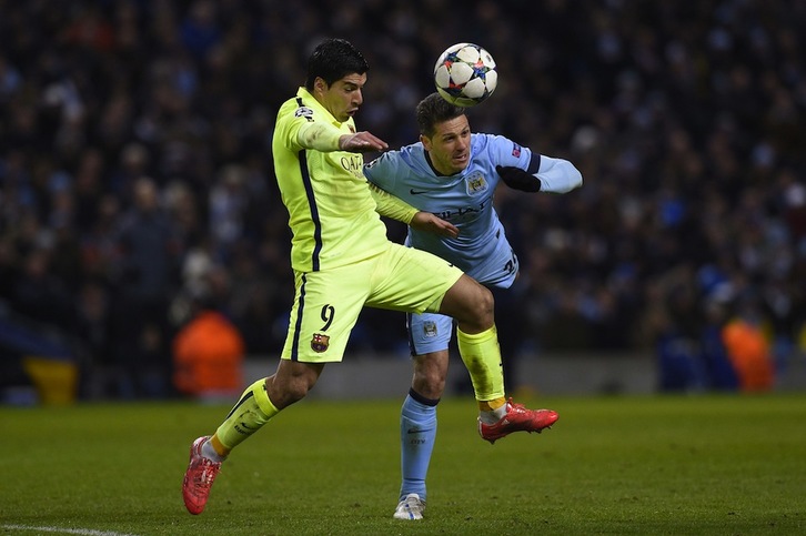 Luis Suárez y Demichelis, disputan una pelota en el Etihad Stadium. (Lluis GENE / AFP)