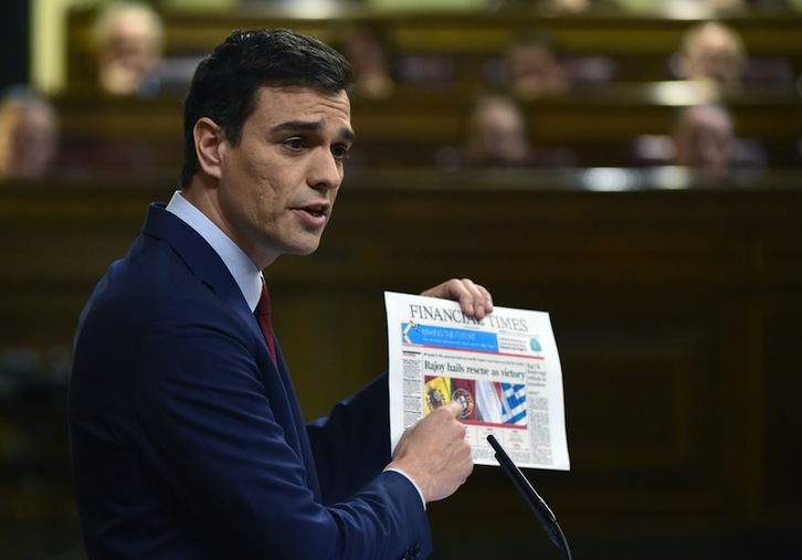 Pedro Sánchez muestra un ejemplar de ‘Financial Times’ en su intervención. (PIerre-Philippe MARCOU/AFP)