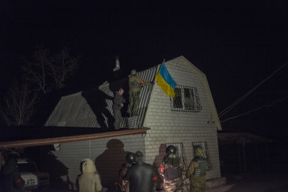 En la casa más alta se coloca una bandera. Será visible desde Rusia, que está a menos de dos kilómetros del pueblo.