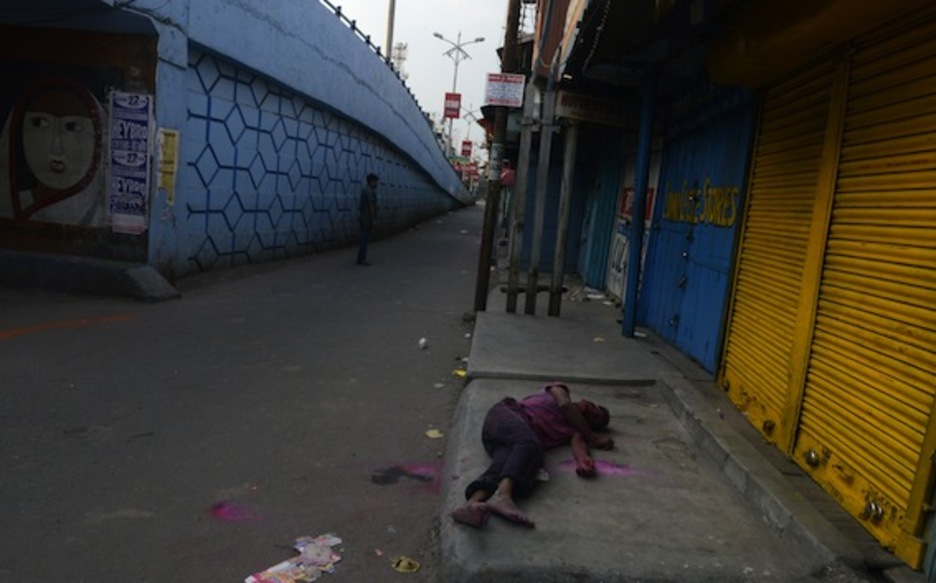 La fiesta se ha hecho demasiado larga para algunos como este joven, que yace dormido en una calle de Siliguri. (Diptendu DUTTA/AFP PHOTO)