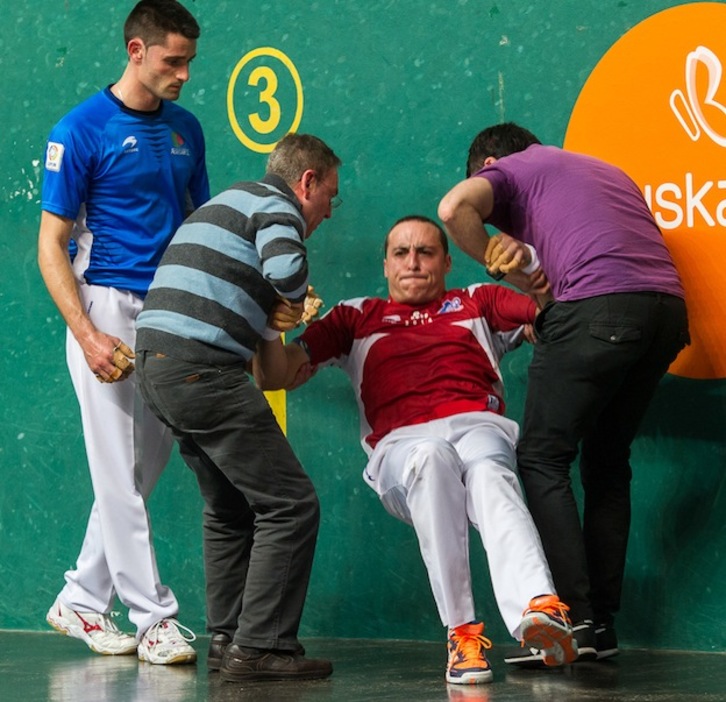 Irujo es ayudado a levantarse tras su lesión. (Juanan RUIZ / ARGAZKI PRESS)