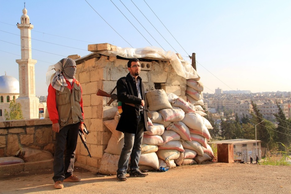 Dos milicianos de las Unidades de Protección Popular (YPG) montan guardia en el barrio de Sheikh Maqsoud, en Alepo. (David MESEGUER) 