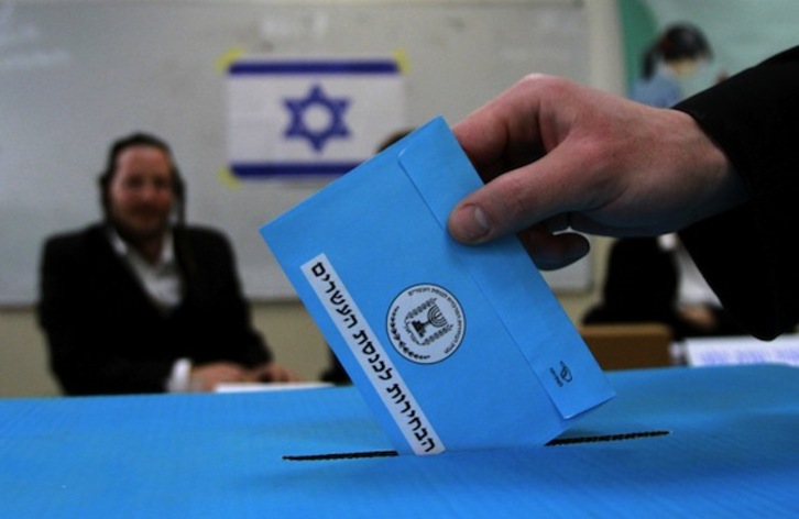 Un hombre depositando su voto, ayer, en un colegio cercano a Tel Aviv. (Gil COHEN MAGEN/AFP PHOTO)