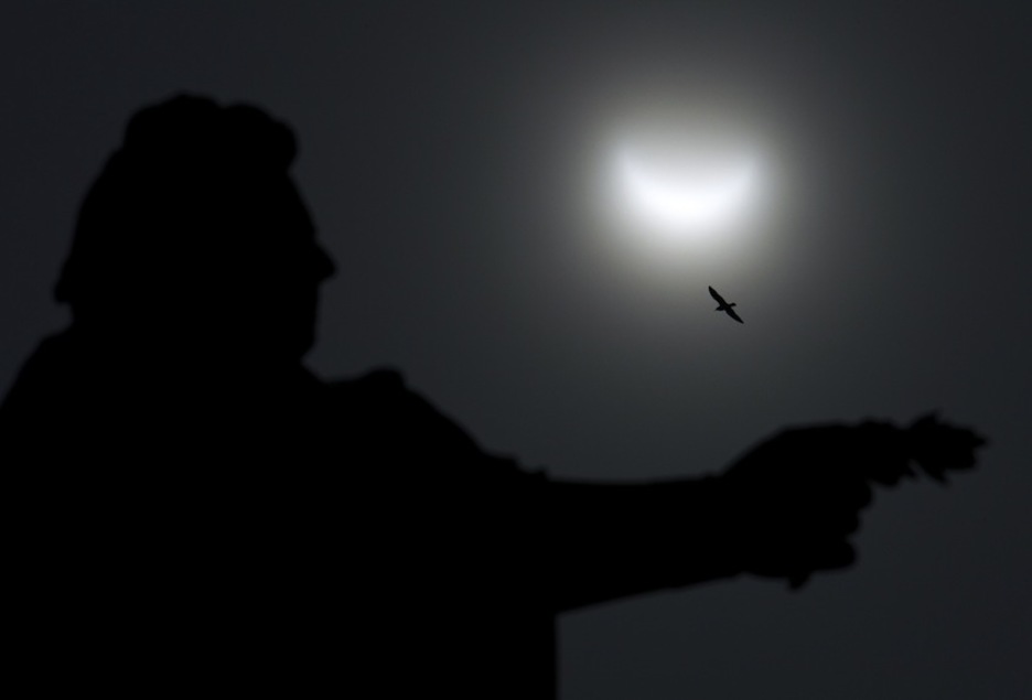 El eclipse en Estocolmo, detrás de la estatua del Rey Gustavo III. (Jonathan NACKSTRAND/AFP)