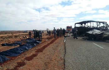 Los cadáveres de las víctimas mortales del accidente yacen junto a la carretara y el autobús calcinado. (AFP)
