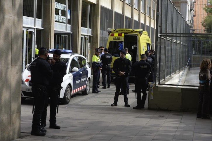 Mossos, policías municipales y servicios médicos, a la entrada del instituto Joan Fuster de Barcelona. (Josep LAGO / AFP)
