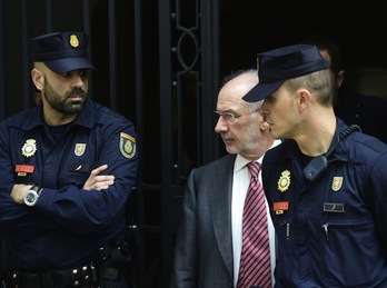 Rodrigo Rato, flanqueado por agentes de la Policía española. (Pierre-Philippe MARCOU/AFP PHOTO)