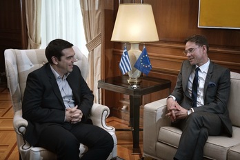 El primer ministro griego, Alexis Tsipras, escucha al vicepresidente de la Comisión Europea, Jyrki Katainen. (Louisa GOULIAMAKI/AFP)