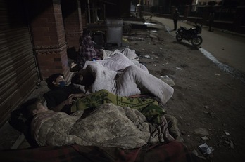 Un grupo de personas se dispone a dormir en una calle de Katmandú. (Nicolas ASFOURI / AFP)