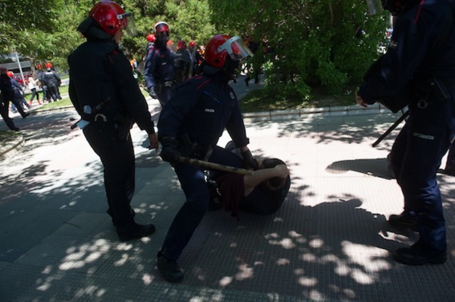 Gazte bat, lurrean, ertzainez inguratuta. (Raul BOGAJO/ARGAZKI PRESS)