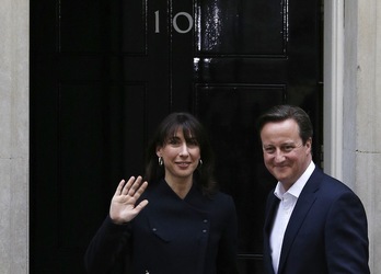 David Cameron y su esposa, ante la puerta de la que seguirá siendo su residencia, el 10 de Downing Street. (Adrian DENNIS / AFP)