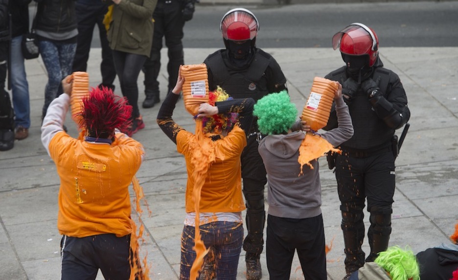 Pintura laranjaz busti dira herri harresiko hainbat gazte. (Raul BOGAJO/ARGAZKI PRESS) Pintura laranjaz busti dira herri harresiko hainbat gazte. (Raul BOGAJO/ARGAZKI PRESS)