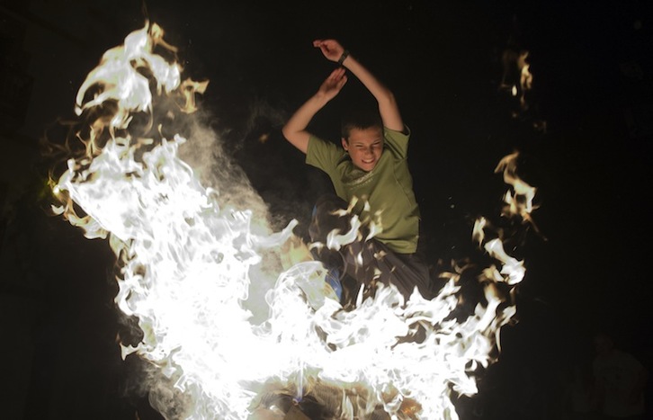 Un chaval salta entre las llamas de una hoguera en Ituren. (Jagoba MANTEROLA/FOKU)