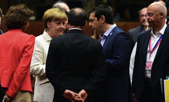 Alexis Tsipras conversa con Angela Merkel y Fraçois Hollande. (John MACDOUGALL / AFP)