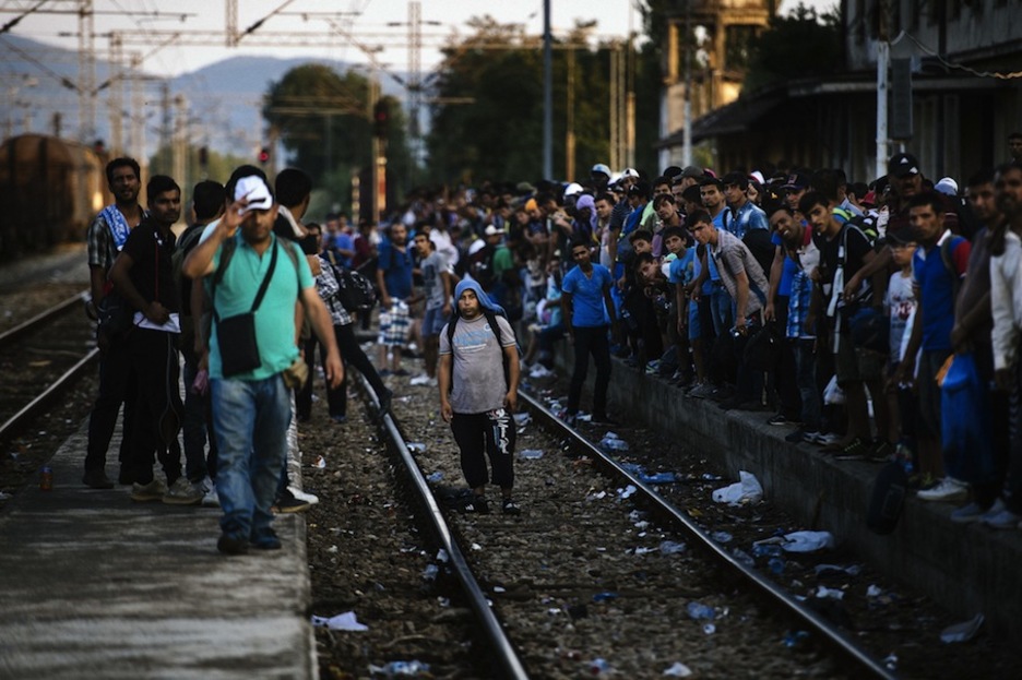 Migrantes esperan al tren en Gevgelija. (Dimitar DILKOFF/AFP)