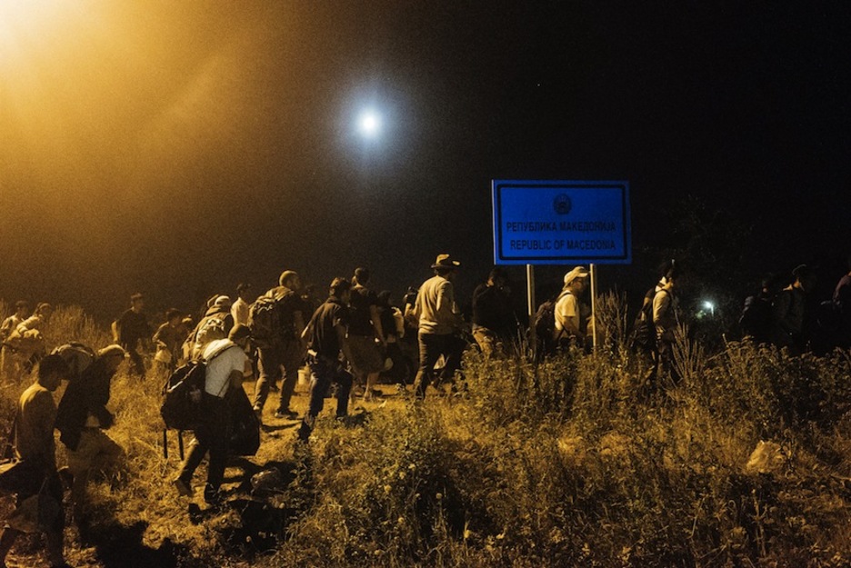 Migrantes cruzan la fronteria entre Serbia y Macedonia en la noche del 27 de julio. (Dimitar DILKOFF/AFP)