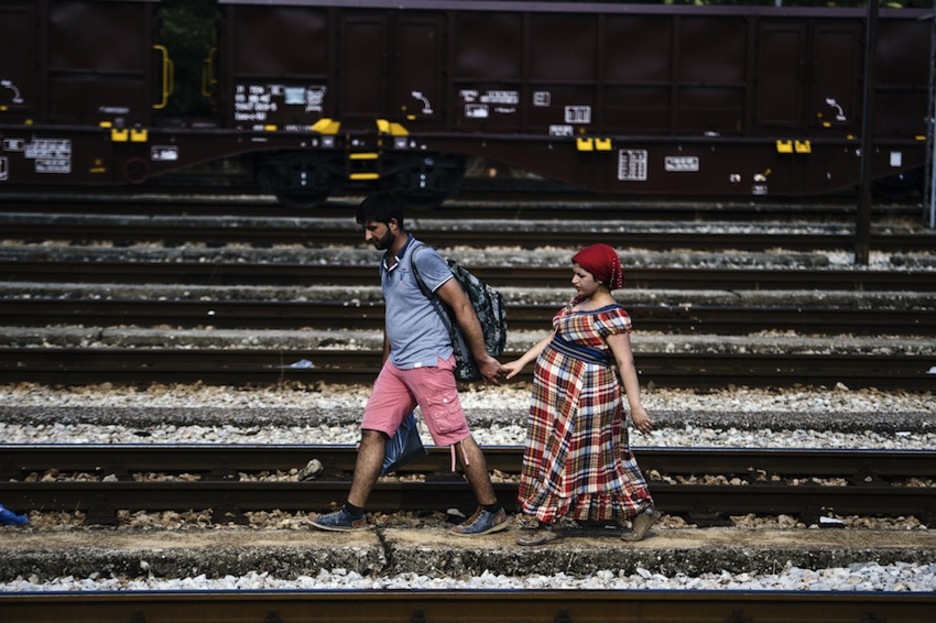 Una pareja camina por las vías del tren en Gevgelija. (Dimitar DILKOFF/AFP) Una pareja camina por las vías del tren en Gevgelija. (Dimitar DILKOFF/AFP)