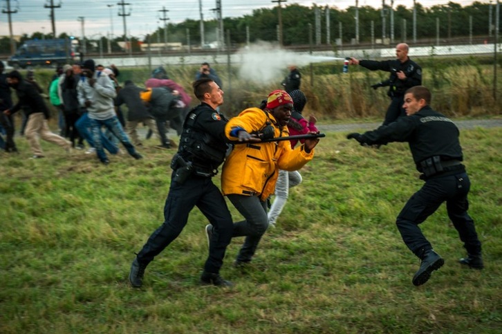 Policías interceptan a un migrante en las instalaciones del Eurotúnel. (Philippe HUGUEN/AFP) 