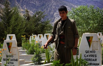 Un miembro del PKK camina entre tumbas en un cementerio en las montañas de Qandil, en una imagen tomada el 29 de julio. (Safin HAMED/AFP PHOTO)