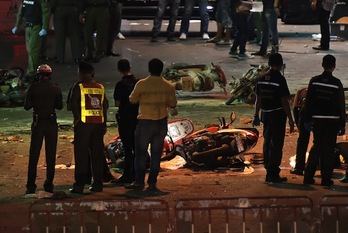 Policías y bomberos observan los destrozos causados por la bomba. (PORNCHAI KITTIWONGSAKUL / AFP)