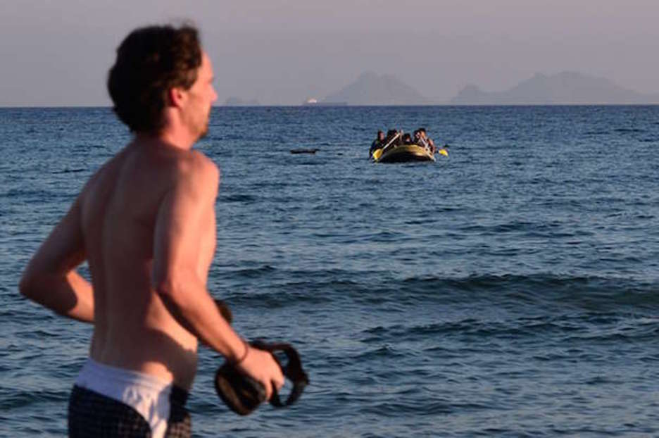 Udatiar bat kirola eginez korrika, iheslarien ontzi bat datorren bitartean Kos irlan. (Louisa GOULIAMAKI) Udatiar bat kirola eginez korrika, iheslarien ontzi bat datorren bitartean Kos irlan. (Louisa GOULIAMAKI)