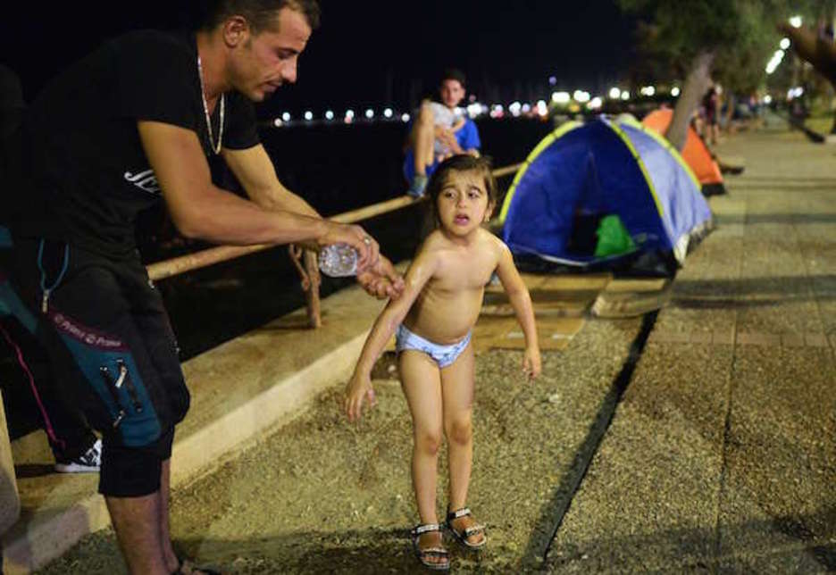 Giuzon irakiar bat bere alaba garbitzen, Kos hirian. (Louisa GOULIAMAKI | AFP) Giuzon irakiar bat bere alaba garbitzen, Kos hirian. (Louisa GOULIAMAKI | AFP)